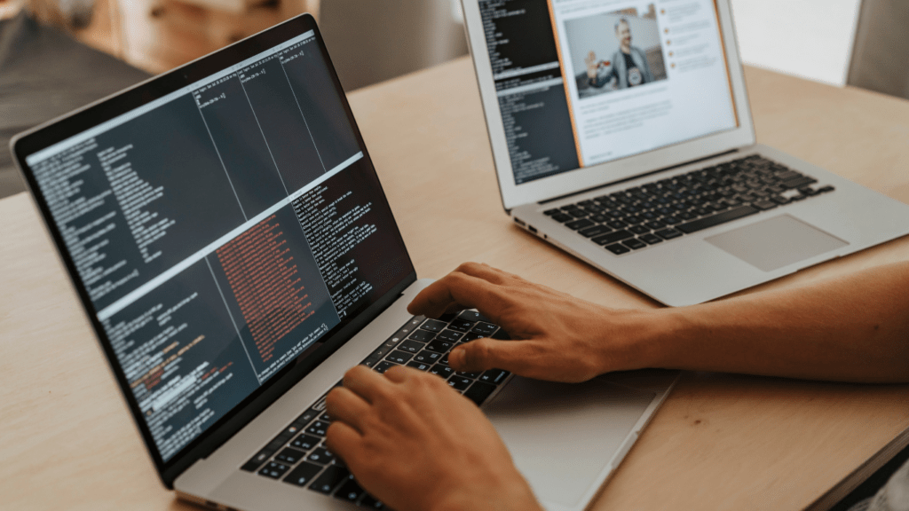 two people working on their laptops in front of each other