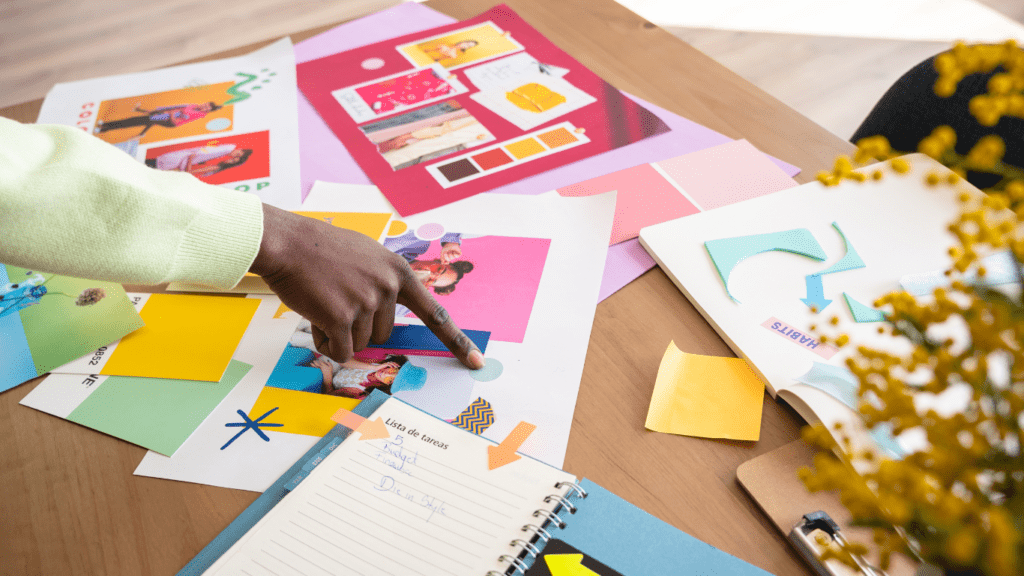 a person sitting at a table with colorful papers