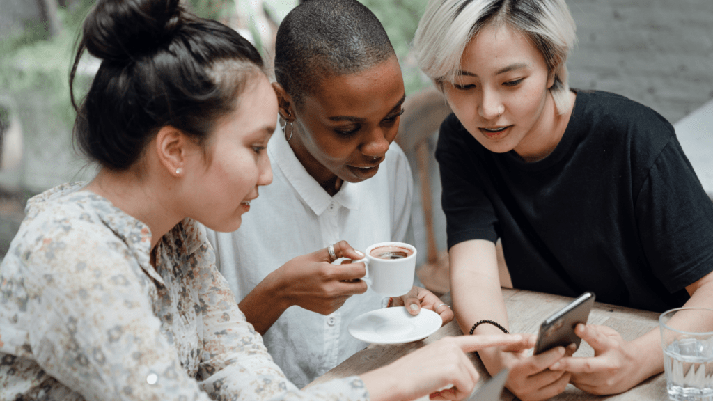 people sitting at a table looking at their cell phones