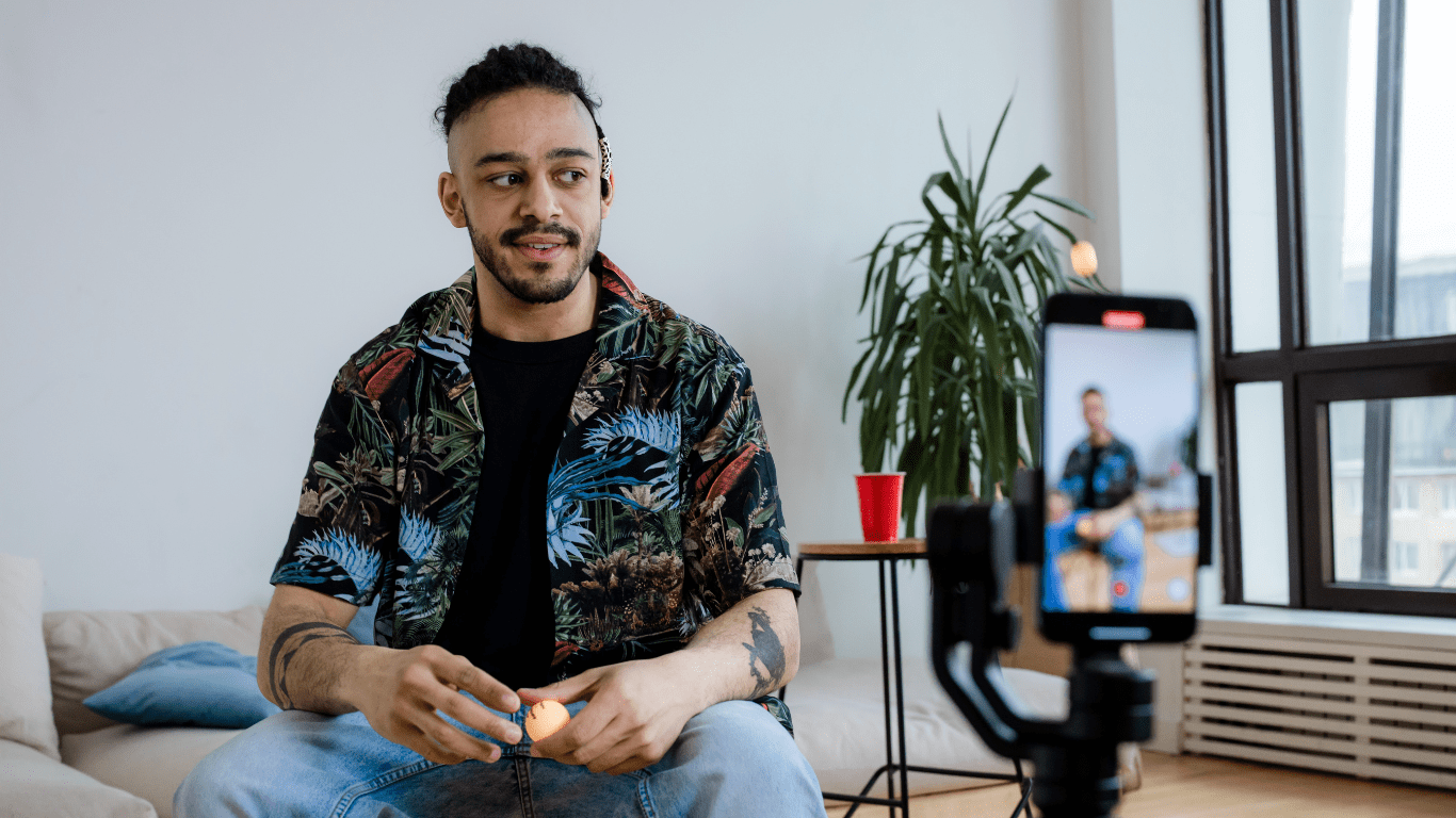 a person sitting in a living room with a camera in front of them