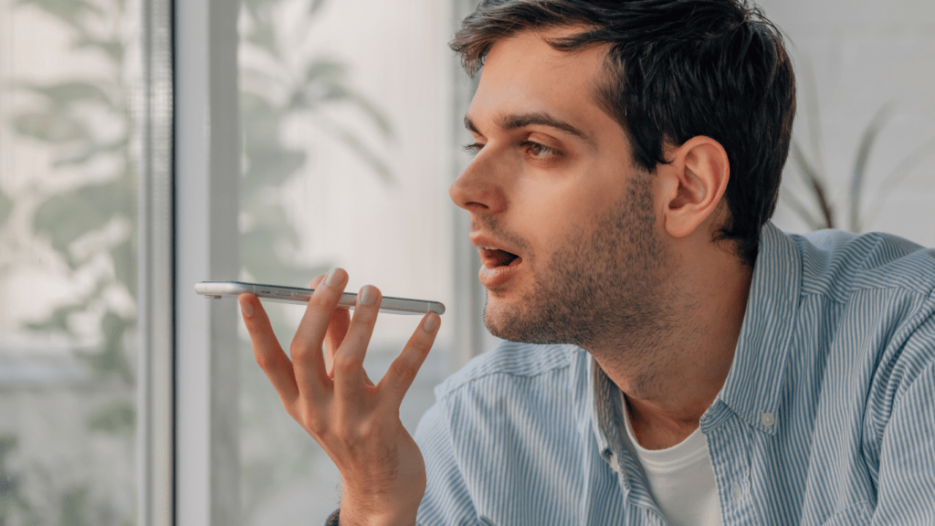 a person is sitting at a table with a cell phone in their hand