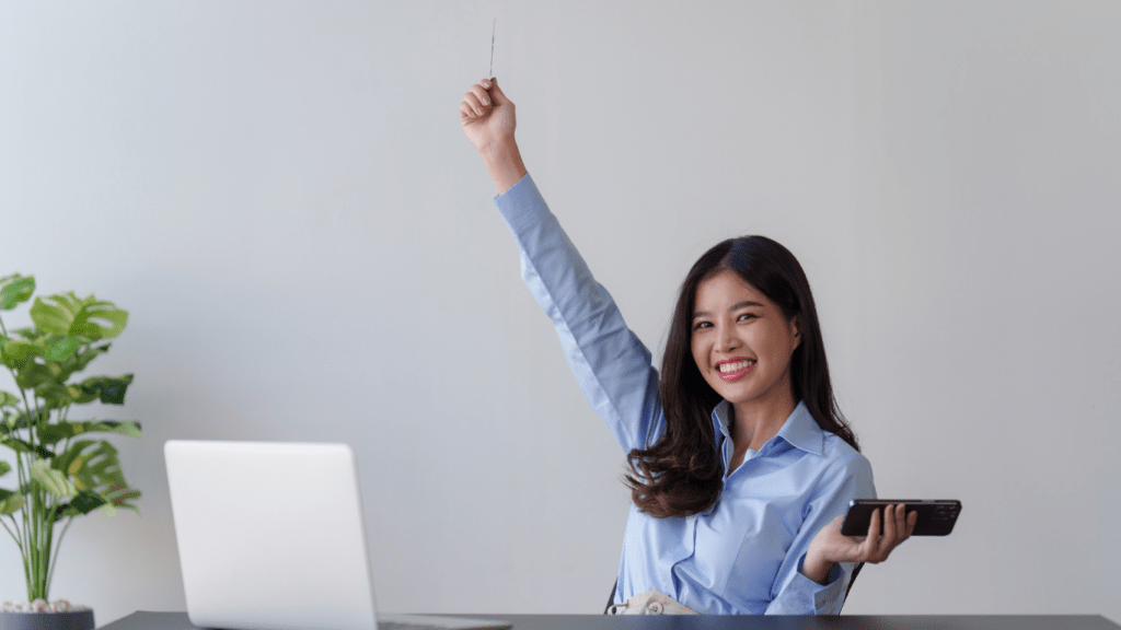 a person is sitting at a desk and raising their hand