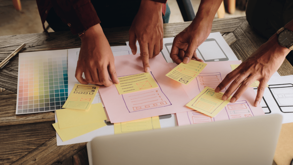 a group of people working on a laptop with sticky notes