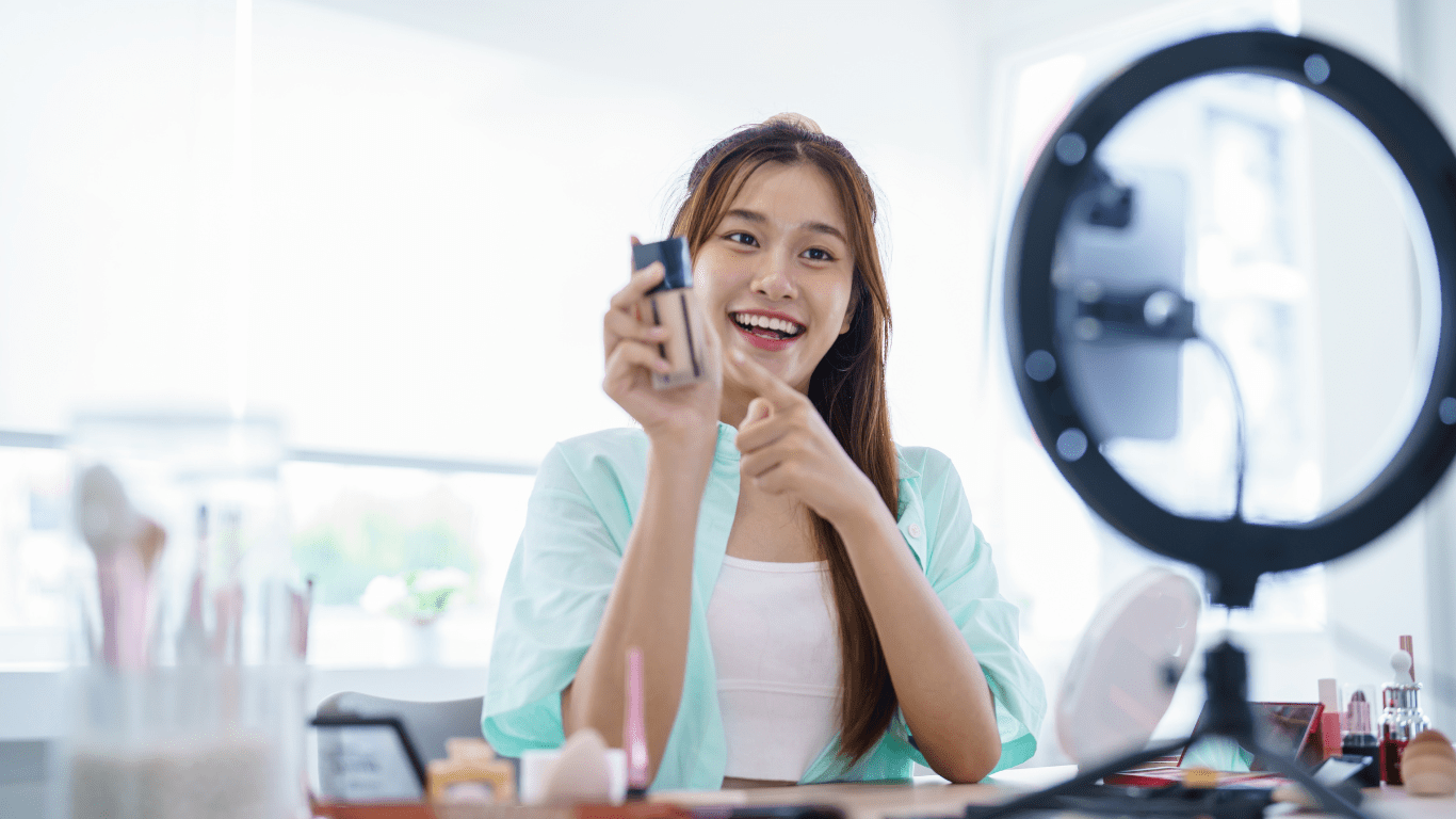 A person is holding up a phone while sitting in front of a mirror