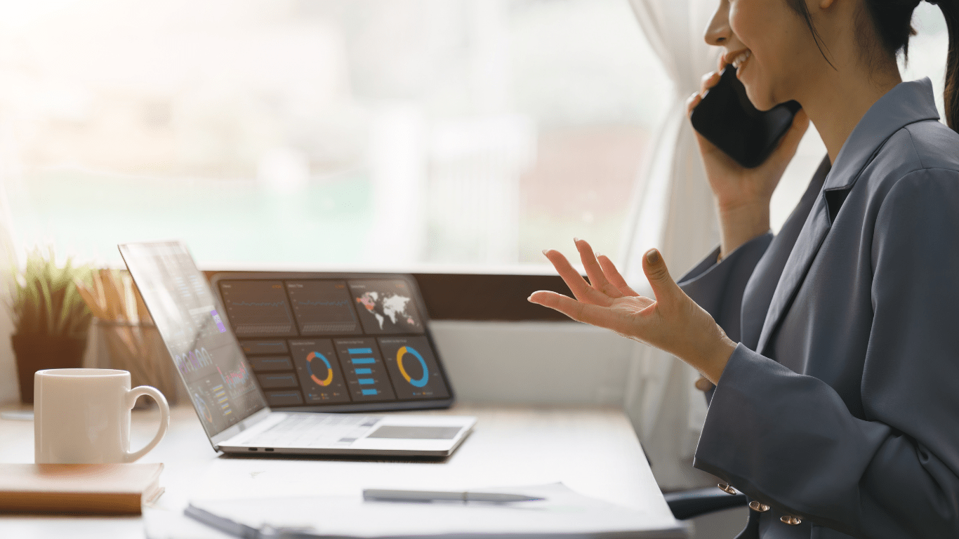 a person is talking on the phone while sitting in front of a laptop