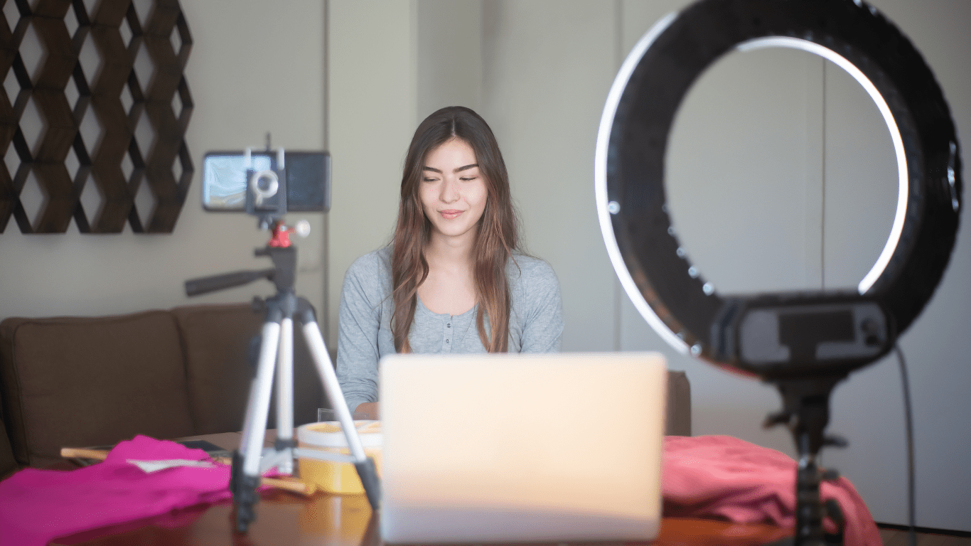 a person sitting in front of a laptop with a ring light