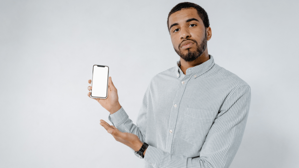 a person is sitting at a table with a cell phone in their hand