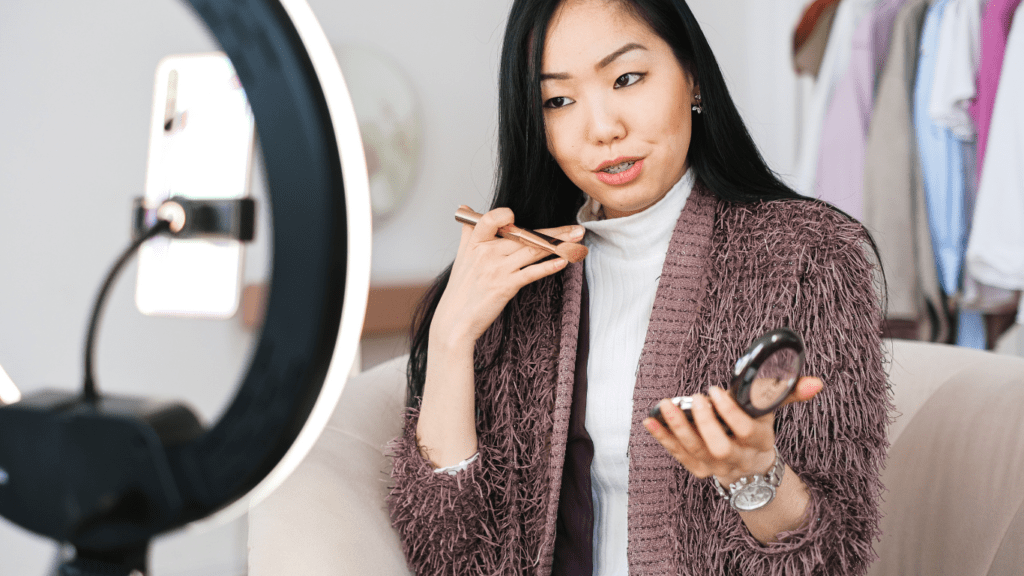 a person sitting in front of a laptop with a ring light