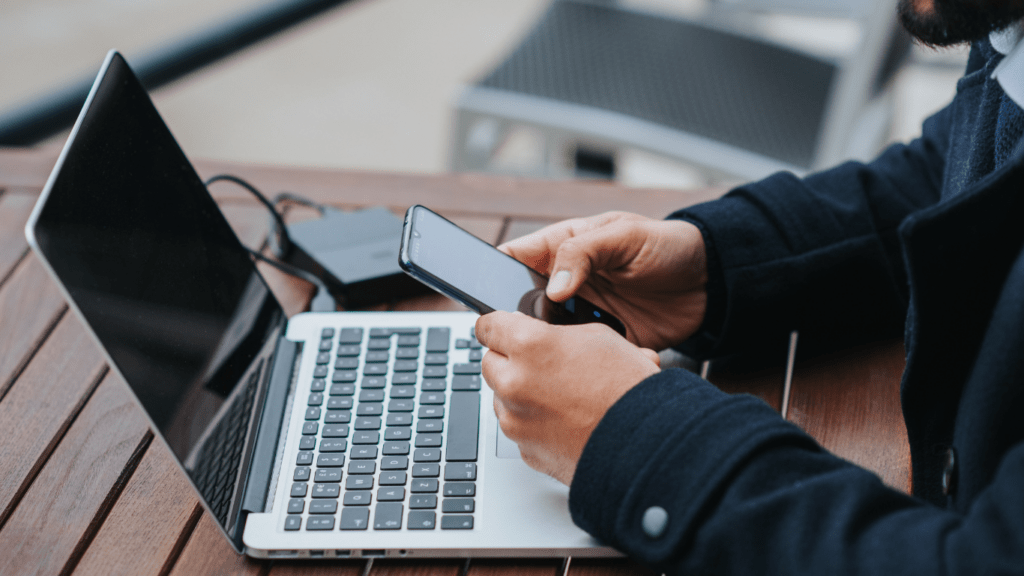 a smartphone and laptop at the table